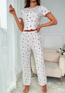 Close-up of pajama set featuring cherry print, vertical stripes and red ruffled lettuce trim