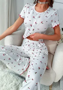 Detail of cherry print pajamas set showing lettuce trim edges and ribbed knit texture