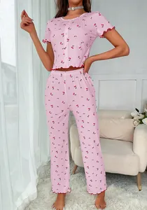 Detail of pink cherry print pajama set with ruffled edges and ribbed texture fabric
