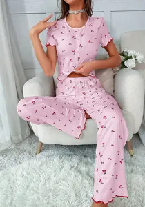 Close-up of pink cherry print pajama set with ruffled edges and vertical texture