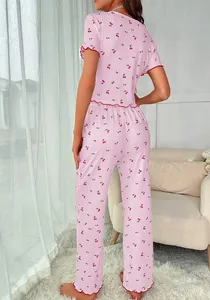 Close-up of pink cherry print pajama set with red lettuce trim and ribbed texture