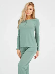Detail view of the ribbed knit fabric and henley button neckline on sage green lounge set