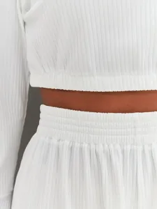 Detailed macro view of white ribbed fabric texture and elastic waistband of the lounge set