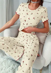 Close-up of cherry print pajama set with lettuce edge trim and ribbed texture fabric