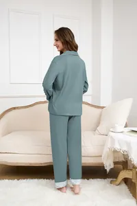 Dettaglio del set da casa blu teal con profili bianchi e bordi in pizzo raffinato