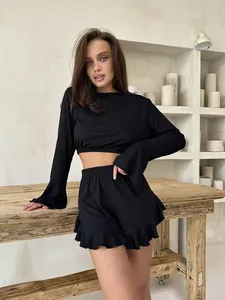 Detail of black ribbed pajama set featuring lettuce edge shorts and long sleeve crop top