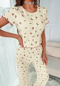 Close-up of cherry print pajama set with red lettuce trim and ribbed fabric texture