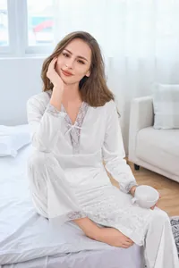 Detailed close-up of white velvet pajamas with delicate lace trim and V-neckline detail