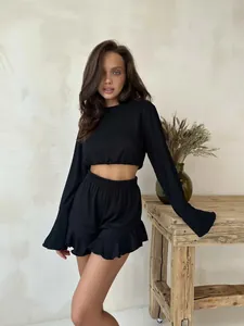 Detail showing the ribbed texture fabric and ruffle trim on black lounge shorts