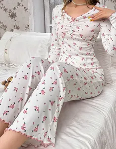 Détail d'un pyjama en maille côtelée à fleurs roses avec bords ondulés et nœud doux