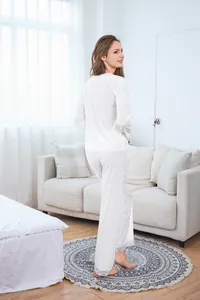 Close-up detail of white velvet pajamas featuring elegant lace trim at the trouser cuffs