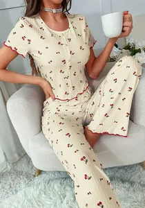 Close-up of cherry print pajama set featuring scalloped red trim and ribbed texture