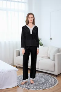Close-up of black velvet pajamas with intricate white lace detailing on sleeves and hem