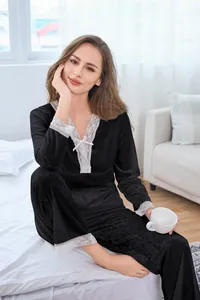 Detailed view of black velvet pajama set featuring white lace trim and bow decorations