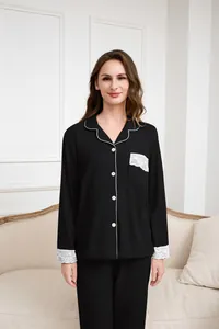 Dettaglio dell'elegante pizzo bianco sui polsini del set pigiama termico nero da donna