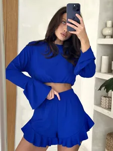 Close-up of royal blue ribbed lounge set showing bell sleeves and ruffled hem details