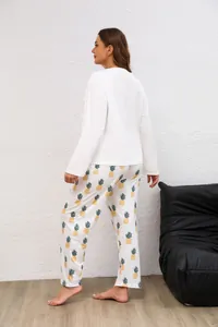 Dettaglio di un set da casa taglie forti con top bianco e pantaloni con stampa ananas