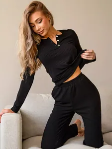 Close-up of black ribbed lounge set featuring white buttons on a long sleeve Henley top