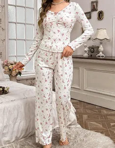 Détail de pyjama fleuri rose avec encolure plissée, nœud décoratif et finitions ondulées