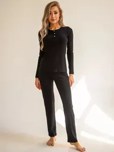 Detail of ribbed knit loungewear set in black with buttons and elastic texture