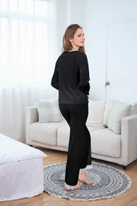 Detail of velvet pajama set with white lace trim and jacquard pattern on black fabric