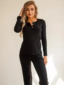 Close-up of black ribbed knit pajamas featuring Henley collar with white buttons