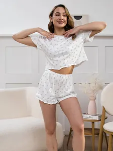 Detail of white pajamas set featuring black heart print and ruffle trim shorts