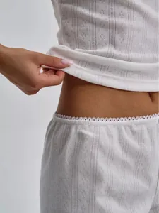 Close-up of white pointelle knit loungewear set featuring delicate lace trim on shorts