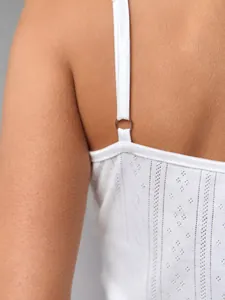 Detailed close-up of white camisole with pointelle knit texture and adjustable metal ring straps