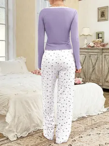 Vista posteriore del top del pigiama a coste lavanda con pantaloni bianchi a fiori