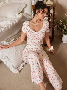 Détail d'un pyjama fleuri avec col en V, bordure en dentelle et tissu côtelé