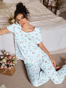 Dettaglio del pigiama floreale da donna con bordo a onde rosa e trama del tessuto a coste