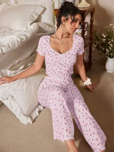 Détail de pyjama rose à fleurs montrant la maille côtelée et la dentelle sur l'encolure