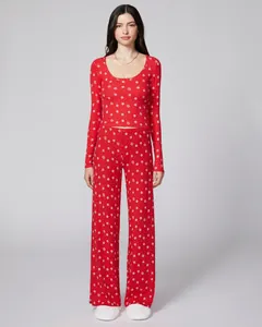 Detail of red Christmas pajamas featuring white snowflake prints and elastic knit fabric