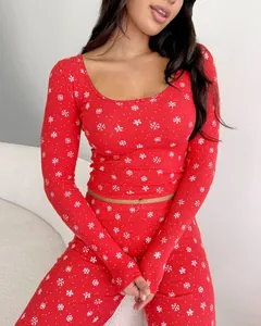 Detail of red ribbed knit pajamas with white snowflakes and a tiny bow decoration