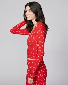 Close-up side view of red Christmas pajama set with white snowflake patterns and V-neck line