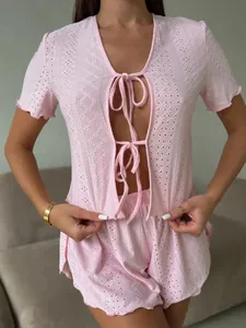 Detail of pink crochet knit pajama set with floral hollow lace and tie-front design