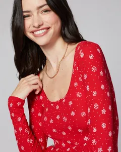Detail of red Christmas pajama top with white snowflake patterns and lace collar