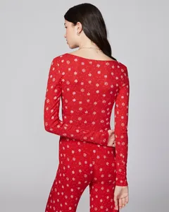 Detail of red Christmas pajamas with white snowflake patterns and ribbed knit texture