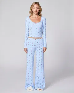 Blue two-piece loungewear set with red bow patterns, featuring U-neck top and wide-leg pants