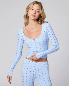 Close-up of light blue loungewear with red bow prints and delicate lace neck detail