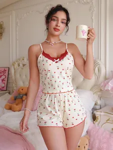 Détail de l'ensemble pyjama imprimé cerises avec bordure en dentelle rouge et petit nœud