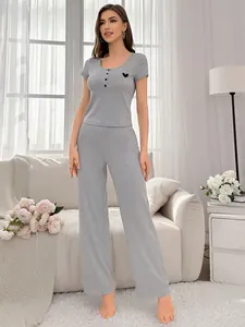 Detail of gray knit pajama set with round neck, buttons and small heart embroidery