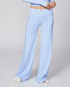 Detail of light blue knit pajama set with red bow patterns and soft fabric texture