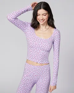 Detail of lavender loungewear set featuring red floral print and wavy collar neckline