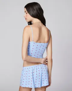 Close-up of light blue camisole set with red bow prints and ribbed knit texture details