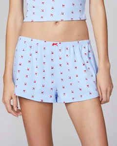 Detail showing the light blue fabric with red bow patterns and waist ribbon detail
