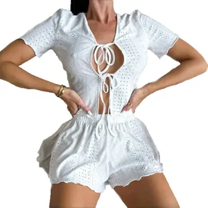 White two-piece eyelet lace summer set with lace-up short sleeve top and wavy hem shorts