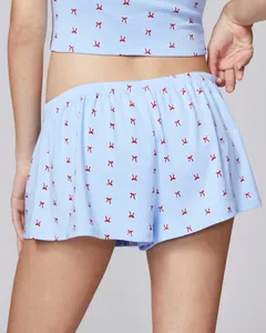 Detail of light blue loungewear set featuring red bow prints and delicate lace trim
