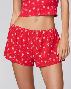 Close-up of red Christmas sleepwear set with snowflake prints and bow detail
